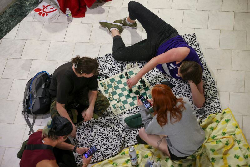 Protestors play chess in the atrium during the public comment portion ahead of the final vote to approve legislation to fund the training center, on Monday, June 5, 2023, in Atlanta. (Jason Getz / Jason.Getz@ajc.com)