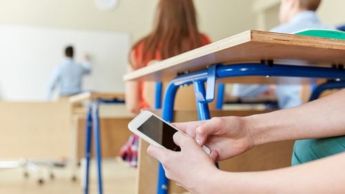 Schools have realized they’ve lost the battle for student attention to the ubiquitous smartphone. Yet many hesitate to ban the phones outright. (Dreamstime/TNS)