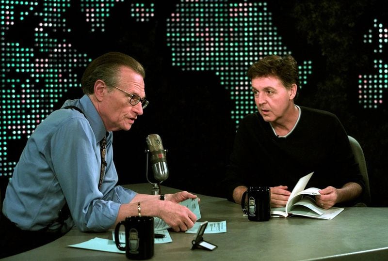 Music legend Paul McCartney, right, reads a poem from his new book: 'Blackbird Singing, Poems and Lyrics 1965-1999,' during an exclusive interview Tuesday, June 12, 2001, with Larry King at the CNN studios in Los Angeles. (AP Photo/Damian Dovarganes)