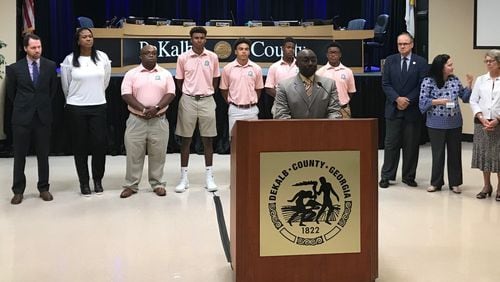 DeKalb County Commissioner Larry Johnson (center) gives remarks during a presentation honoring the members of Charles R. Drew Charter School's golf team. The team won the state championship earlier this year.  The team is standing with their coaches and other members of the DeKalb Board of Commissioners. (TIA MITCHELL/TIA.MITCHELL@AJC.COM)