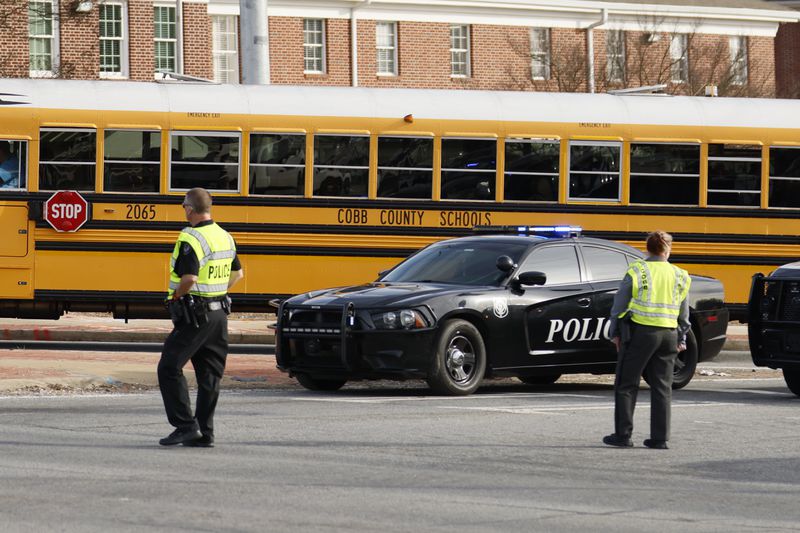 Cobb County police officers direct traffic at McEachern High School after two people were shot in the parking lot of the Powder Springs school on Feb. 1, 2024. (Miguel Martinez /miguel.martinezjimenez@ajc.com)