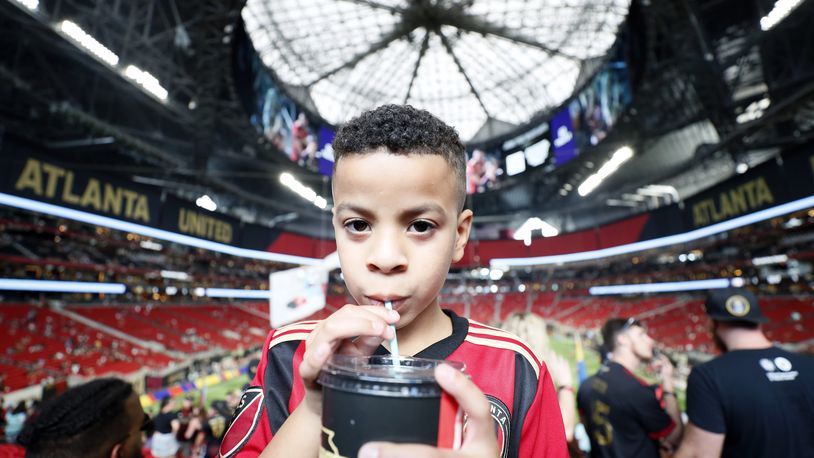 Maximo Suarez (7) from Lawrenceville takes a sip through the new biodegradable straw that the Mercedes-Benz stadium implemented on Sunday, July 17, 2022. "My parents have taught us to recycle everything at home; I know where the aluminum and plastic go, same as the glass and cardboard boxes," Suarez said. Miguel Martinez /miguelmartinezjimenezajc.com