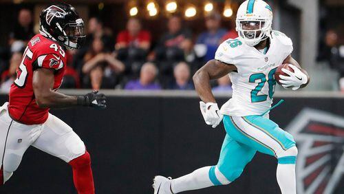 Miami Dolphins running back Damien Williams (26) runs as Atlanta Falcons middle linebacker Deion Jones (45) defends during the first half of an NFL football game, Sunday, Oct. 15, 2017, in Atlanta. (AP Photo/David Goldman)