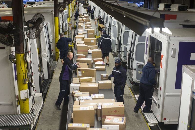 Alpharetta, GA, - FedEx employee belt pullers fill trucks with packages for their daily route at the FedEx shipping center in Alpharetta. ALYSSA POINTER/ALYSSA.POINTER@AJC.COM