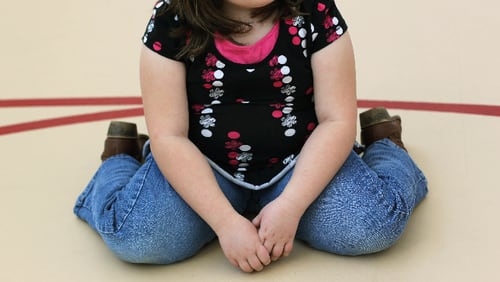A child sits on the gym floor during the Shapedown program for overweight adolescents and children on November 13, 2010 in Aurora, Colorado.