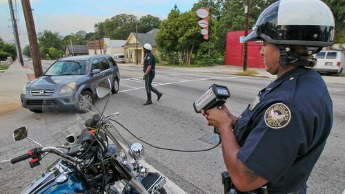 Atlanta Police Officers T. Chambliss (foreground) and D. Brown (background) catch a speeder with their laser guns on Hope Street and Metropolitan Avenue on August 9, 2012. JOHN SPINK / JSPINK@AJC.COM