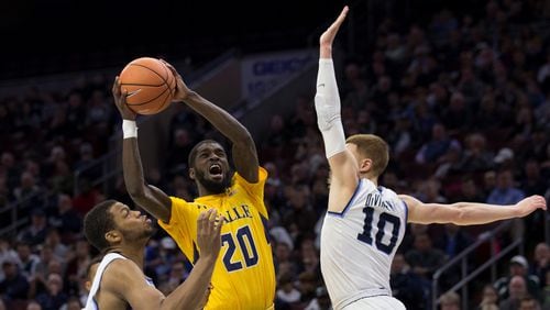 B.J. Johnson #20 of the La Salle Explorers attempts a shot against Omari Spellman #14 and Donte DiVincenzo #10 of the Villanova Wildcats in the second half at the Wells Fargo Center on December 10, 2017 in Philadelphia, Pennsylvania. The Wildcats defeated the Explorers 77-68. (Photo by Mitchell Leff/Getty Images)