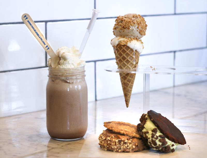 The Honeysuckle Gelato shop at Ponce City Market sells shakes, scoops and sandwiches. The shake was made with a scoop of dark chocolate and a scoop of bourbon gelato, then topped with whipped cream. There are chocolate chip and brown sandwiches, and a cone of brown butter gelato and honey fig gelato, topped with amaretti crumbles.