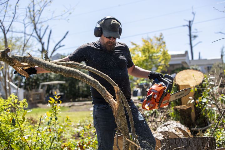Jason Rose cleans up downed trees in the backyard of his mother’s property in Newnan. (Alyssa Pointer / Alyssa.Pointer@ajc.com)