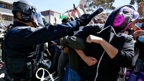 FILE - A protester is hit with a baton by a police officer at UC San Diego, May 6, 2024, in San Diego. As pro-Palestinian demonstrations escalate on college campuses around the country, critics of President Joe Biden’s handling of the Israel-Hamas war suggest this summer’s Democratic National Convention could be marred by protests and scenes of chaos that undermine his reelection. It raises the specter of a replay of 1968’s Democratic convention in Chicago, where a violent police crackdown created indelible scenes of chaos. (AP Photo/Denis Poroy, File)