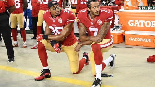 The San Francisco 49ers' Colin Kaepernick, right, and Eric Reid kneel in protest during the national anthem prior to playing the Los Angeles Rams at Levi's Stadium on Sept. 12, 2016, in Santa Clara, California. (Thearon W. Henderson/Getty Images/TNS)