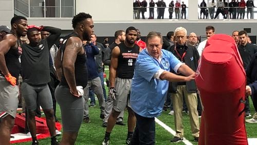 New England coach Bill Belichick instructs former Georgia linebackers Davin Bellamy  (center), Lorenzo Carter (far left) and Reggie Carter (rear) on how to run a drill at the Bulldogs’ Pro Day Wednesday in Georgia’s indoor practice facility in Athens.