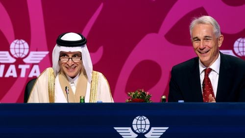 Qatar Airways Chief Executive Officer Akbar Al Baker, left, and International Air Transport Association director Tony Tyler laugh during the the IATA's annual meeting held this year in Doha, Qatar, Monday, June 2, 2014. Tyler says the group will prepare a draft of new recommendations in September to improve global tracking capabilities in the aftermath of the disappearance of Malaysia Airlines Flight 370. (AP Photo/Osama Faisal)