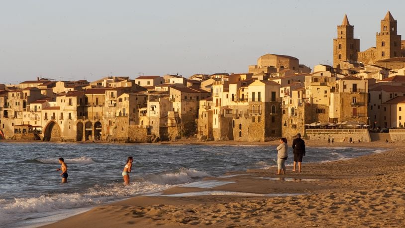 The beach at Cefalu, Italy, a picturesque town in Sicily, May 19, 2016. For older travelers, the best thing about returning to a well-known destination is that you lose the greedy compulsion to go everywhere and see everything. (Susan Wright/The New York Times)