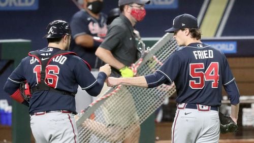 Braves starting pitcher Max Fried, right, gets a fist bump from catcher Travis d'Arnaud after the third inning against the Los Angeles Dodgers in Game 1 Monday, Oct. 12, 2020, for the best-of-seven National League Championship Series at Globe Life Field in Arlington, Texas. (Curtis Compton / Curtis.Compton@ajc.com)