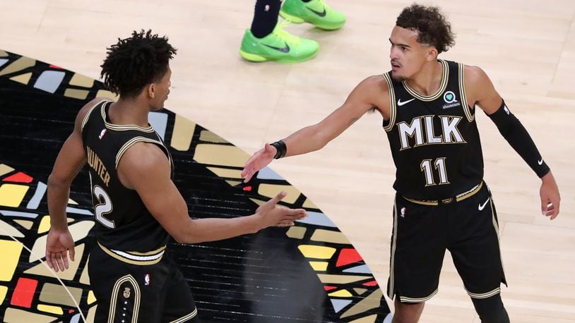 Atlanta Hawks guard Trae Young and forward De’Andre Hunter celebrate a 108-97 victory over the Minnesota Timberwolves in the MLK Day Unity game Monday, Jan. 18, 2021, at State Farm Arena in Atlanta. The Rev. Dr. Martin Luther King Jr.'s hometown honored the civil-rights icon with jerseys featuring the letters “MLK” - a first in the NBA. (Curtis Compton / Curtis.Compton@ajc.com)