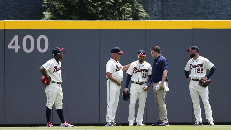 Manager Brian Snitker #43 of the Atlanta Braves talks to center fielder Ender Inciarte while left fielder Ronald Acuna, right fielder Nick Markakis and a trainer look on after Inciarte ran into the centerfield wall in the fourth inning against the Miami Marlins Sunday May, 20, 2018, at SunTrust Park in Atlanta.