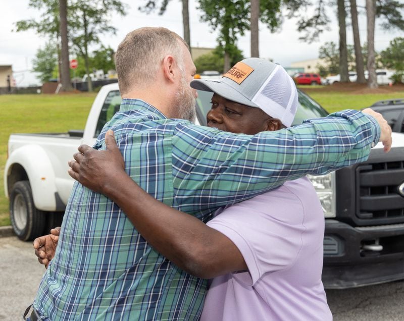 Randy Simpkins (left) and Russell Dallas hug as they meet at Hunter Park in Douglasville.  PHIL SKINNER FOR THE ATLANTA JOURNAL-CONSTITUTION