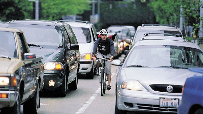 Both drivers and bicycle riders need to know the laws and be aware of each other to prevent accidents. Bike messenger Caitlin McElroy is shown in this file photo. (Seattle Times)