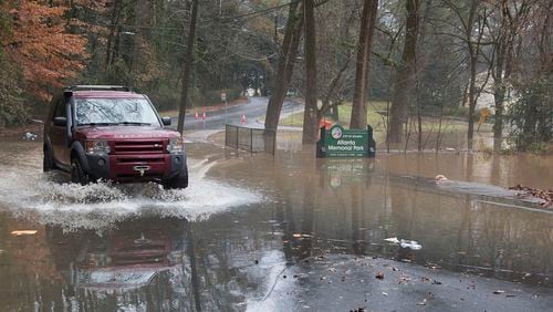 An SUV drives through floodwaters covering parts of Peachtree Battle Ave after the Peachtree Creek overflowed it's banks with rain water on Friday December 28th, 2018. (Photo by Phil Skinner)