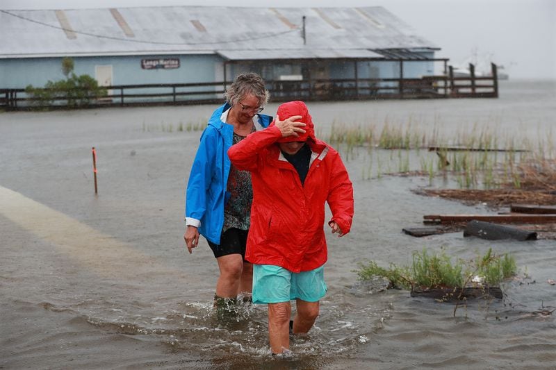 September 4, 2019 St. Mary's: Jen Fabrick (left) and Anne Herring (right) walk through flood waters on St. Maryâs Street at Langs Marina near their homes while Hurricane Dorian passes by on Wednesday, Sept. 4, 2019, in St. Mary's.   Curtis Compton/ccompton@ajc.com