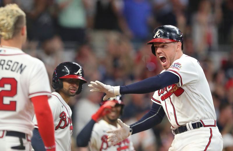 On to the NLCS: Freddie Freeman celebrates with teammates after his solo home run in the eighth inning of Tuesday's game. Freeman's home run sealed the 5-4 victory over the Brewers which sent the Braves to the National League Championship Series for the second straight year. (Curtis Compton/ccompton@ajc.com)