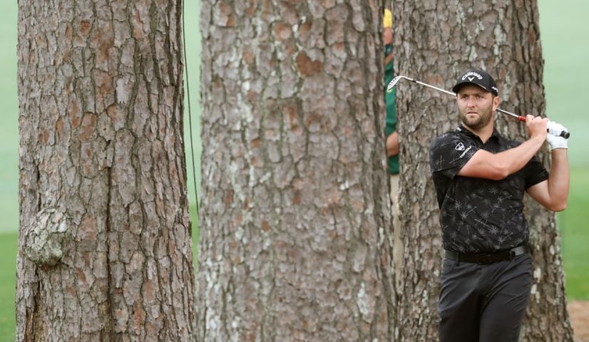 April 10, 2021, Augusta: Jon Rahm hits out of the woods off of the second fairway during the third round of the Masters at Augusta National Golf Club on Saturday, April 10, 2021, in Augusta. Curtis Compton/ccompton@ajc.com