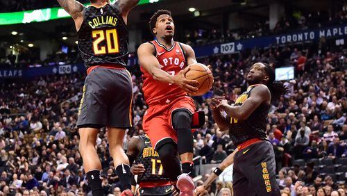 Toronto Raptors guard Kyle Lowry (7) drives between Atlanta Hawks forwards John Collins (20) and Taurean Prince during the second half of an NBA basketball game Tuesday, March 6, 2018, in Toronto. (Frank Gunn/The Canadian Press via AP)