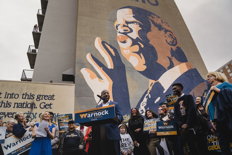 U.S. Sen. Raphael Warnock speaks in front of a mural of the late U.S. Rep. John Lewis. Warnock's win in the 2021 runoffs, helping Democrats gain control of the U.S. Senate, and Atlanta's rich civil rights history are both being touted as reasons the city should host the 2024 Democratic National Convention. (Nicole Craine/The New York Times)