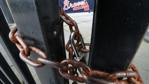 March 31, 2020 Atlanta: The third base gate to the Atlanta Braves Truist Park is chained shut while the stadium sits empty on Tuesday, March 31, 2020, in Atlanta.