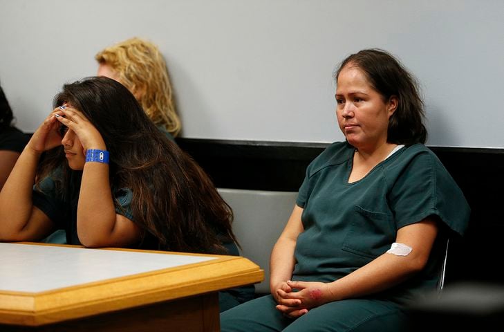 Mother charged with stabbing family smiles in court