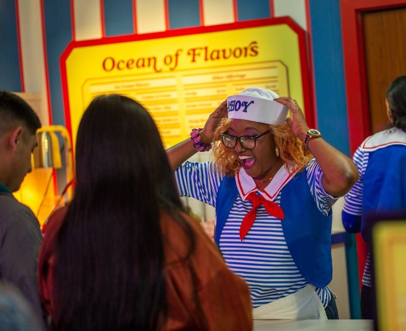 "Stranger Things: The Experience" at Pullman Yards ends in the Mix-Tape lounge where Brianna Spires takes ice cream orders at the Scoops Ahoy ice cream shop Friday, Nov. 11, 2022.  (Jenni Girtman for The Atlanta Journal-Constitution)