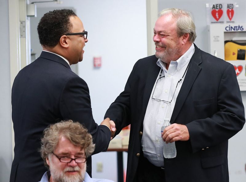 Fort Mac LRA Chairman Cassius Butts, left, greets developer Stephen Macauley at a board meeting for the McPherson Implementing Local Redevelopment Authority earlier this month. Curtis Compton/ccompton@ajc.com