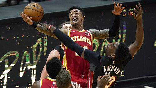Atlanta Hawks forward John Collins (center top) is fouled by Miami Heat center Bam Adebayo (right) during the second half Sunday, Feb. 28, 2021, in Miami. (Lynne Sladky/AP)