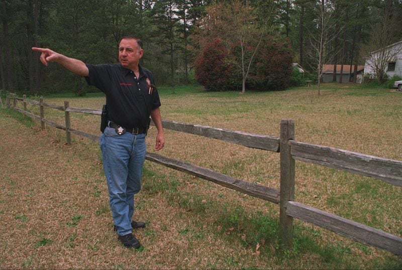 New Hope, Georgia - Paulding County Sheriff Bruce Harris on March 28, 1997, at the site where a jet plane came to rest in April 1977. He is pointing to the direction that the plane came from as the co-pilot tried to land the plane on Dallas-Acworth Road. (AJC Staff Photo/Kimberly Smith)