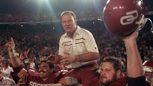 Oklahoma Sooners coach Barry Switzer gets a ride from jubilant players Tony Casillas, left, and an unidentified player, right, following their win over Penn State in the 1986 Orange Bowl.