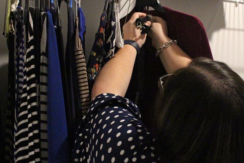 Katie Hearn scans a label on a piece of clothing with her “Pen Friend” so that she can tell what the piece of clothing looks like at her apartment beside SunTrust Park. A friend helped Katie as she recorded her voice describing the items. JENNA EASON / JENNA.EASON@COXINC.COM