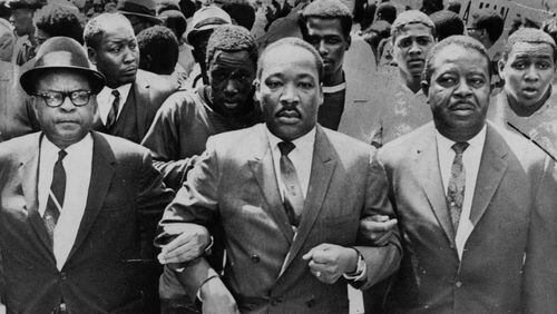 The late Bishop B. Julian Smith of the Episcopal District of the Christian Methodist Church, left, and Rev. Ralph Abernathy, right, flank Dr. Martin Luther King, Jr., during a civil rights march in Memphis, Tenn., March 28, 1968. (AP Photo/Jack Thornell)