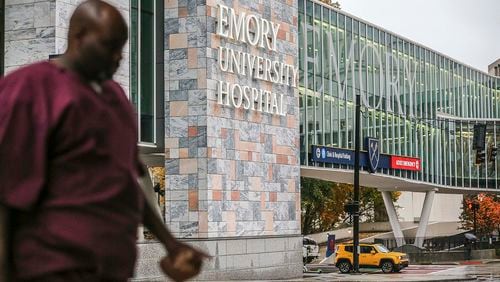 Medical personnel walk the campus at Emory Hospital. JOHN SPINK/JSPINK@AJC.COM