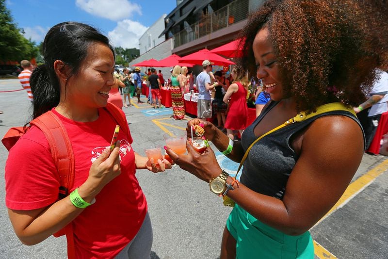 TOMAHTO, TOMATO--072113 ATLANTA: -- Leeanna Lim (left) and Giselle Bell, both of Atlanta, sample some oyster shooters and tomato moonshine at the JCT.Kitchen & Bar annual Attack of the Killer Tomato Festival on Sunday, July 21, 2013, in Atlanta. CURTIS COMPTON / CCOMPTON@AJC.COM