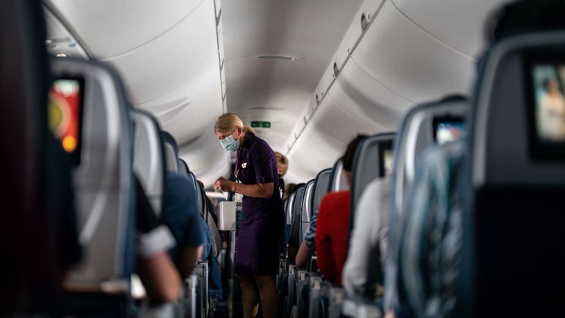 Flight attendants hand out refreshments to a packed Delta Air Lines flight on Friday, May 21, 2021. Delta is asking the U.S. Justice Department to create a national no-fly list of passengers who have been convicted for on-board disruptions. (Kent Nishimura/Los Angeles Times/TNS)