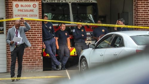 Atlanta police homicide commander Lt. Ralph Woolfolk works the scene of a fatal shooting at Atlanta Fire Rescue Station 31 on Fairburn Road. A victim was pronounced dead inside a white sedan parked outside the engine bay.