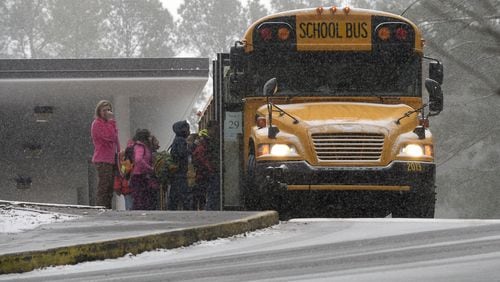 Sagamore Hills Elementary School students board a DeKalb County school bus for early dismissal as a major winter storm dumps 1 to 3 inches of snow on the metro Atlanta area, Tuesday, Jan. 28, 2014. David Tulis / AJC Special DAVID TULIS / AJC SPECIAL