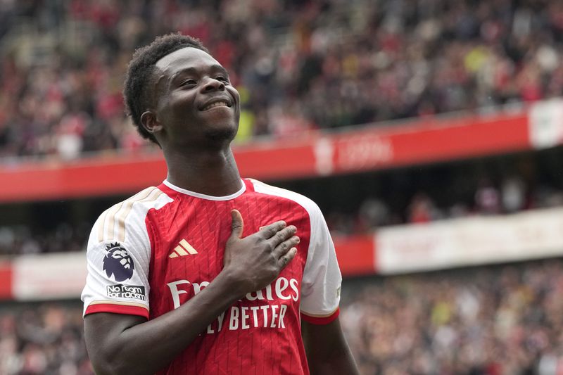 Arsenal's Bukayo Saka celebrates after scoring his side's opening goal during the English Premier League soccer match between Arsenal and Bournemouth at Emirates Stadium in London, England, Saturday, May 4, 2024. (AP Photo/Frank Augstein)