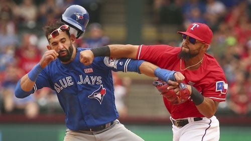 After Jose Bautista caused a benches-clearing incident Wednesday with a bat flip after a homer with his team down five runs, Braves pitcher Eric O’Flaherty referenced this famous punch that Bautista (left) took from Rangers second baseman Rougned Odor in May 2016. (AP file photo)