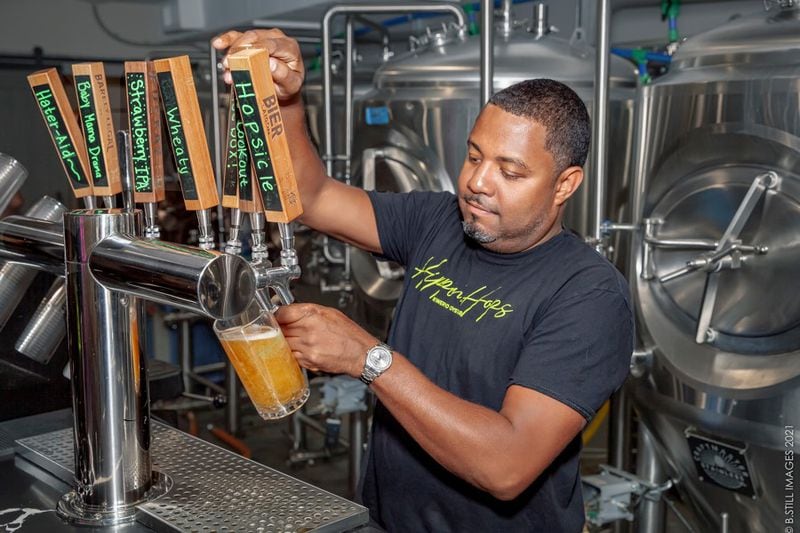 Hippin Hops co-owner Clarence Boston draws a beer from the tap at his East Atlanta brewery and oyster bar. (Courtesy of NIkole B. Still)