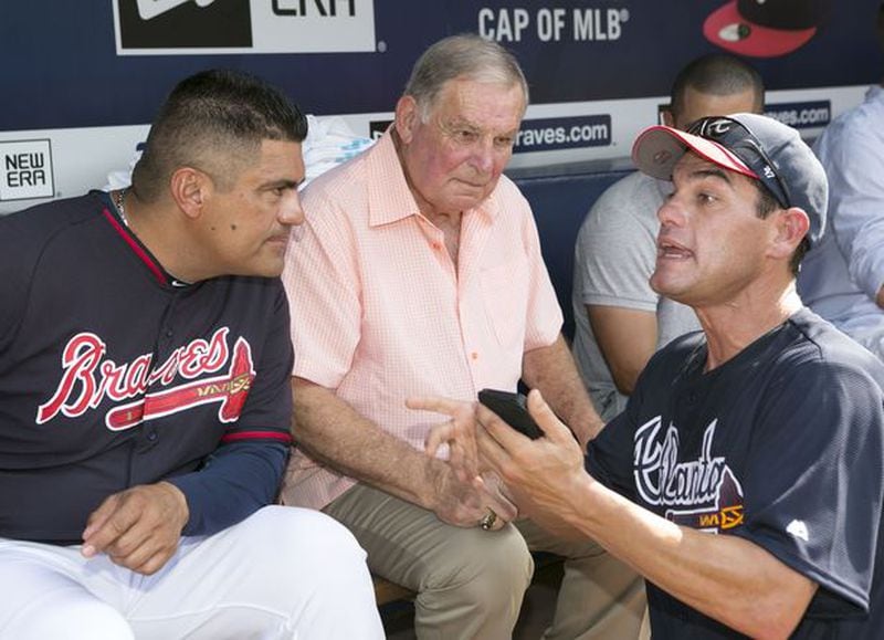 Eddie Perez (left) and former Braves manager Bobby Cox (center) listen to Marcus Giles go on during Braves alumni weekend in 2015. (AJC/Phil Skinner photo)
