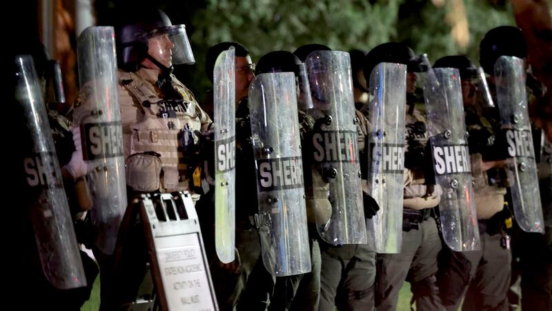 A line of Pima County Sheriff's deputies form a shield line as law enforcement gathers outside an encampment of pro-Palestinian protesters encamped on the University of Arizona campus, early Wednesday, May 1, 2024 in Tucson, Ariz. (Kelly Presnell/Arizona Daily Star via AP)