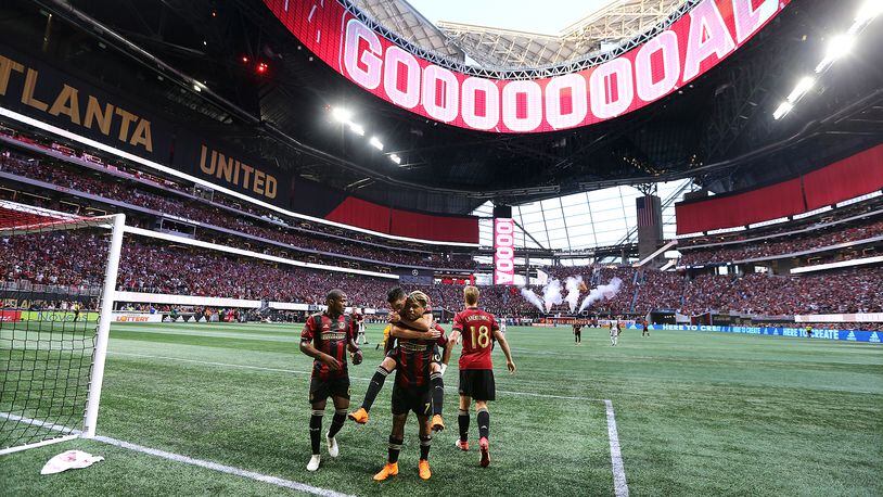 June 2, 2018 Atlanta: The roof of Mercedes-Benz Stadium is open as Atlanta United forward Josef Martinez celebrates his goal on a penalty kick with teammates while Miguel Almiron jumps on his back for a 1-0 lead against Philadelphia Union during the first half in a MLS soccer match on Saturday, June 2, 2018, in Atlanta.  Curtis Compton/ccompton@ajc.com