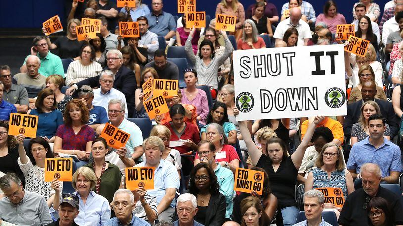 Many area residents hold signs in opposition as Cobb officials and environmental regulators hold a town hall and community forum in the wake of reports that Cobb and Fulton have high levels of carcinogenic gas on Monday, August 19, 2019, in Marietta. Curtis Compton/ccompton@ajc.com